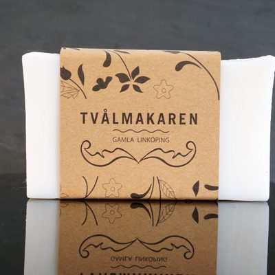 Ekologisk Handgjord tvål. Rektangulärgformad och inslagen i brunt papper med Tvålmakarens logga på. Vit färg, Återfuktande.