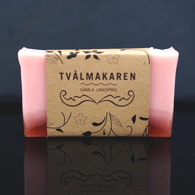 Ekologisk Handgjord tvål. Rektangulärgformad och inslagen i brunt papper med Tvålmakarens logga på. Rosa färg med röd botten, doft av Energi.