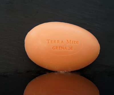Tvål formad som gåsägg. Tryckt text på ovansidan. Orange färg, doft av granatäpple.